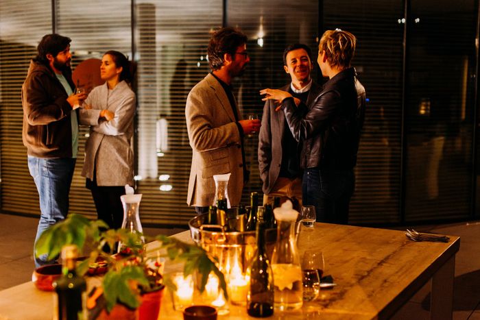 photo of people chatting next to a wooden table