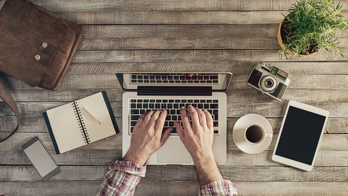 An overrhead shot of a man working on his laptop