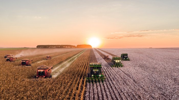 An image of farm machinery working in a field at sunset - what are stock photographs