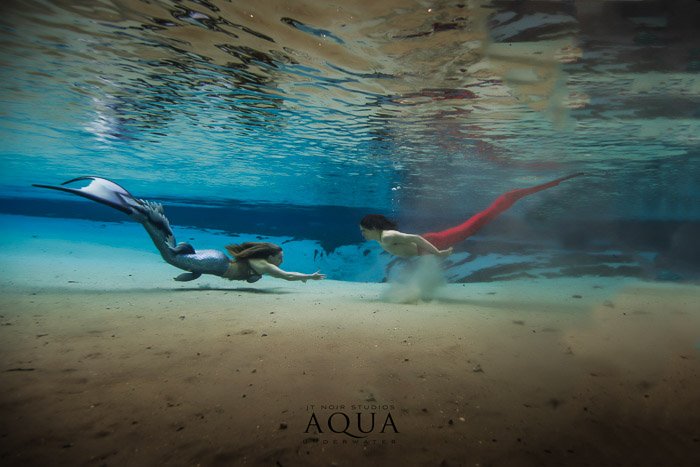 An underwater photography advertising shot of two mermaids