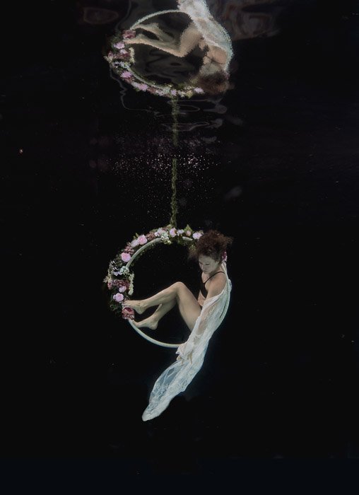 Beautiful and atmospheric photo of a girl posing underwater on a hoop