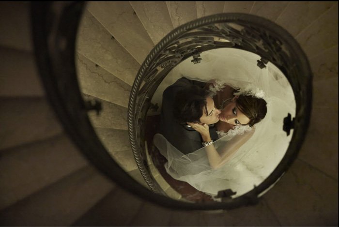 Photo of a bride and groom framed by a spiral starcase from the wedding blog of Jerry Ghionis