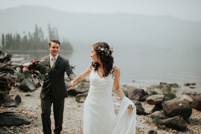 Um belo retrato de casamento de um casal recém-casado de mãos dadas em uma praia