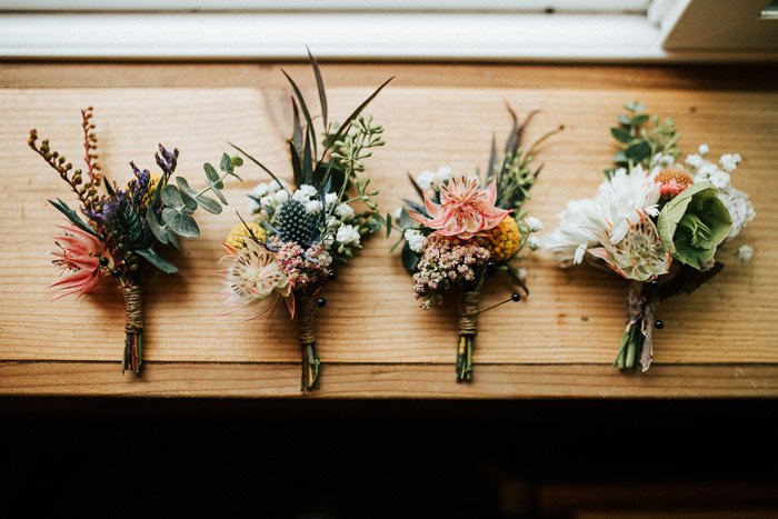 Overhead still life of four wedding flower bouquets on a wooden surface