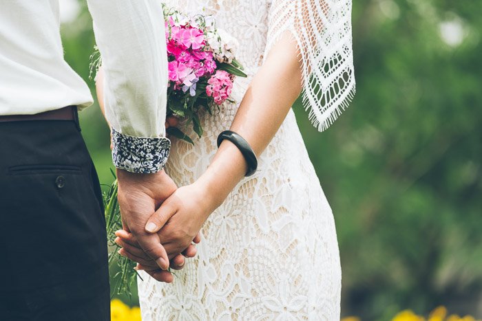 Close up of a newlywed couple holding hands