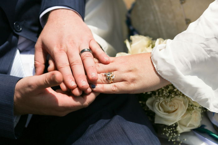 Close up wedding portrait of the groom holding the brides hand - event photography guide