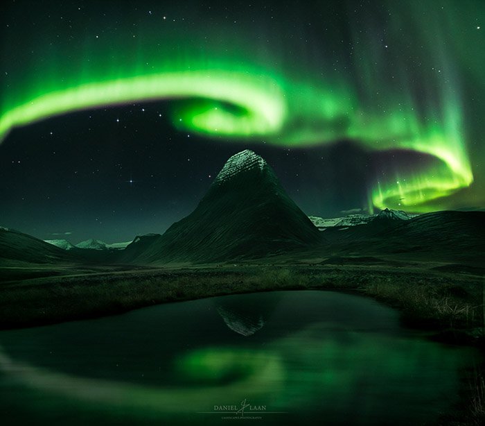 Stunning shot of the northern lights swirling over a mountainous landscape