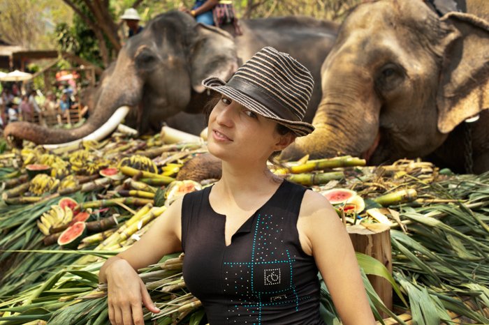  European woman tourist enjoys being with elepants on National Elephant Day in Thailand 