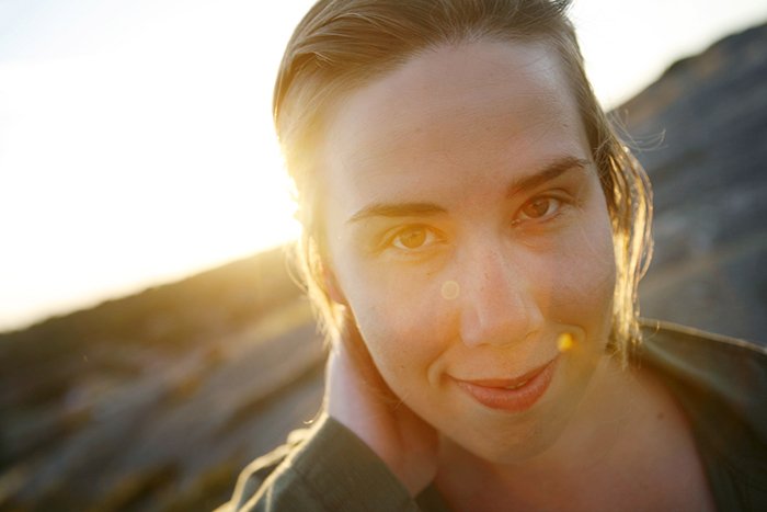 Close-up portrait of smiling woman during sunset.