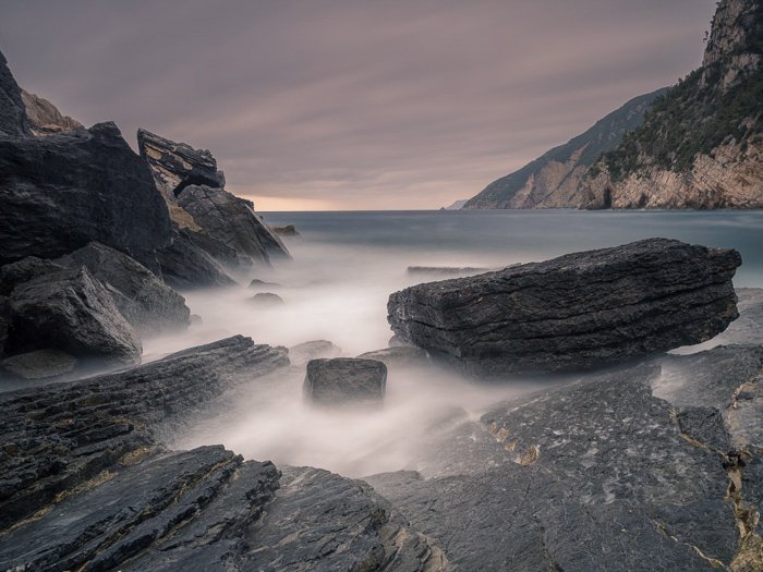 foto de larga exposición de las rocas y las olas en la costa de Porto Venere al amanecer.