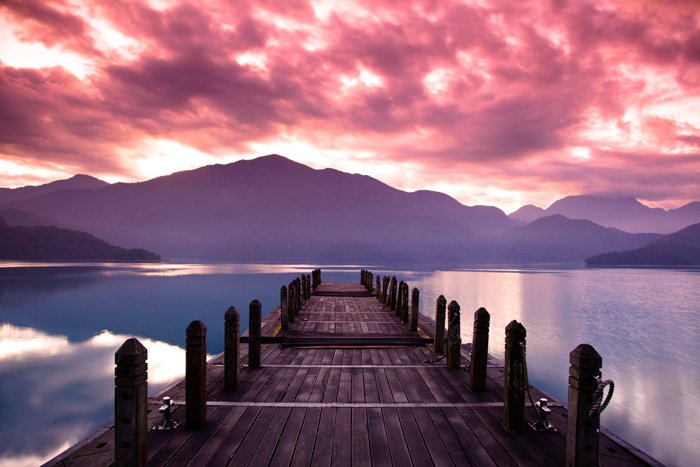 A wooden pier on a lake during a beautiful sunset