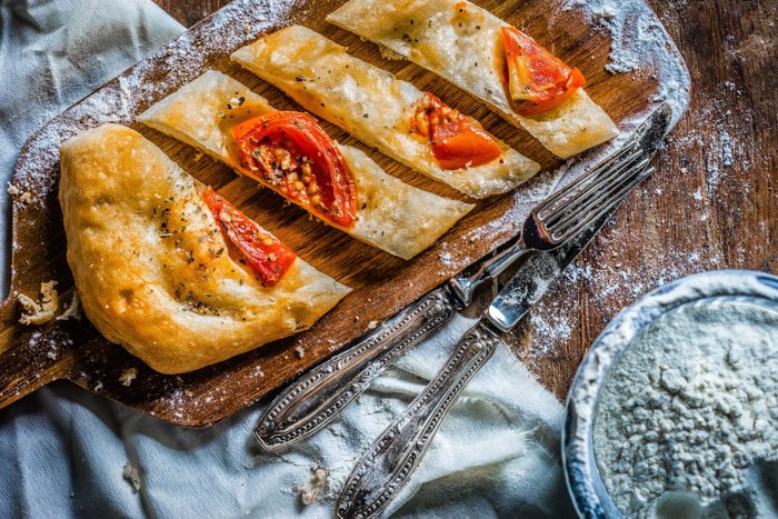 flatbread with tomatoes on a wood tray
