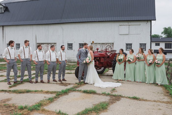 A large wedding party pose outdoors in a farmyard area- camera focus for sharp group photography 