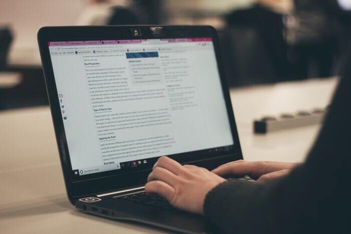 Photo of a person typing on a laptop