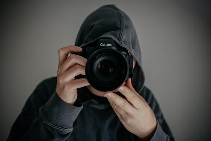 Photo of a guy in a hoodie with a camera