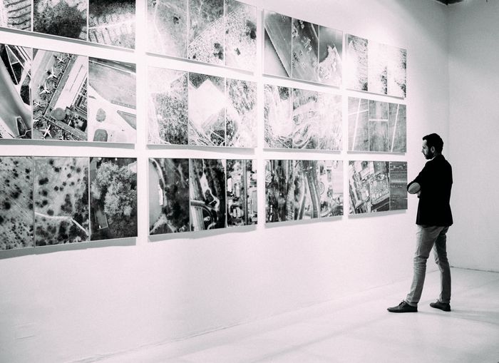 Photo of a guy looking at photos at a gallery