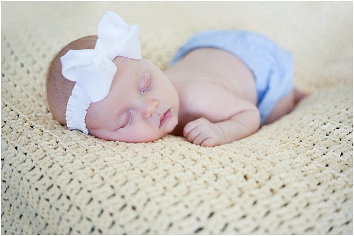 sleeping baby in a blue diaper and white headband