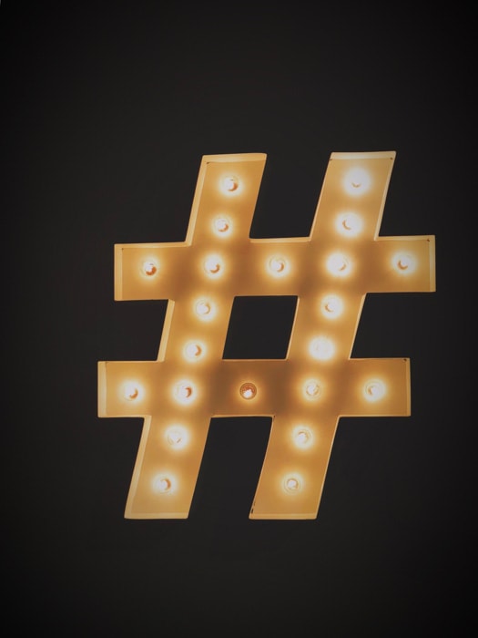 A golden Instagram hashtag on black background