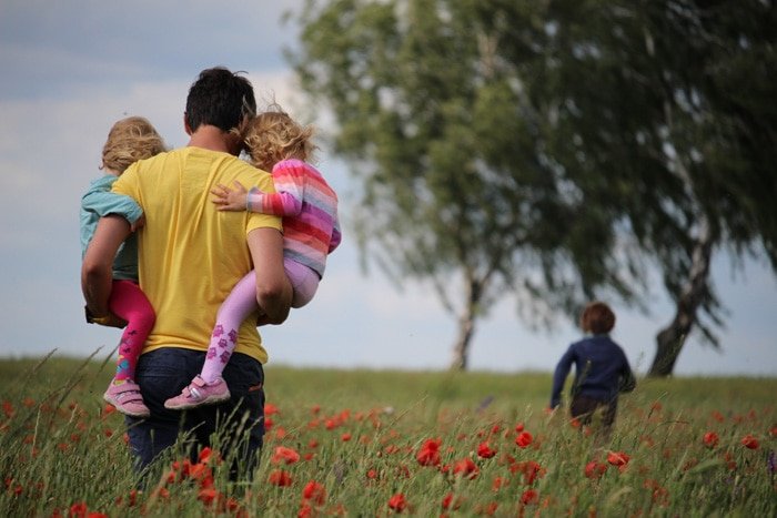A family walking through a poppy field