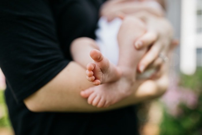 Blurry close up photo of a man holding a newborn baby 