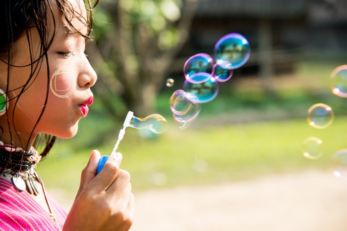 close up portrait of a little girl blowing bubbles - portrait photography props