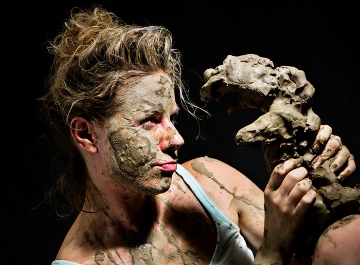 a portrait of a female ceramic artist working with clay as photography props