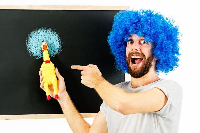 Man in a blue wig with a rubber chicken.