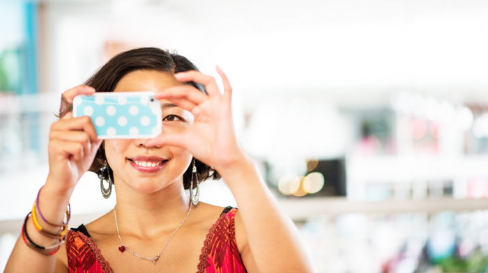 Woman using a smart phone to take a photograph.