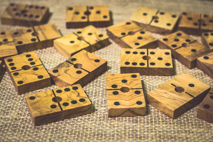 close up of several wood domino tiles on a brown table.