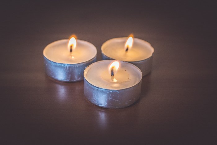 close up of three lit tealight candles