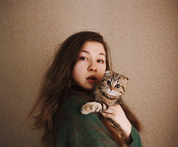 Artistic portrait of a female model posing with a stripy cat - creative selfies
