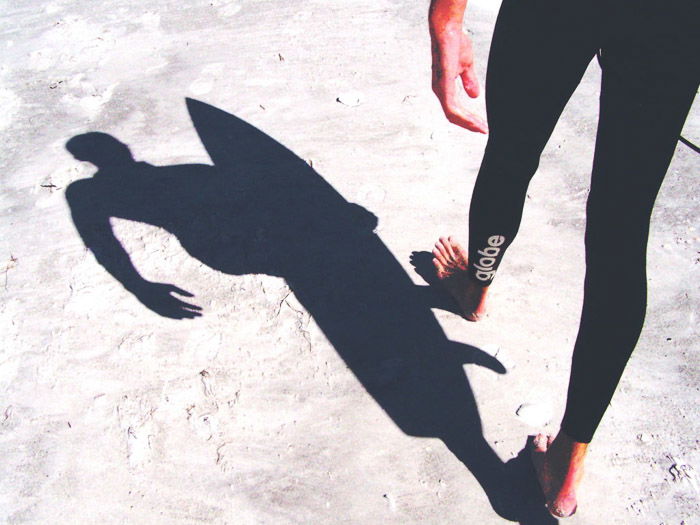 the shadow of a person walking on a stone ground