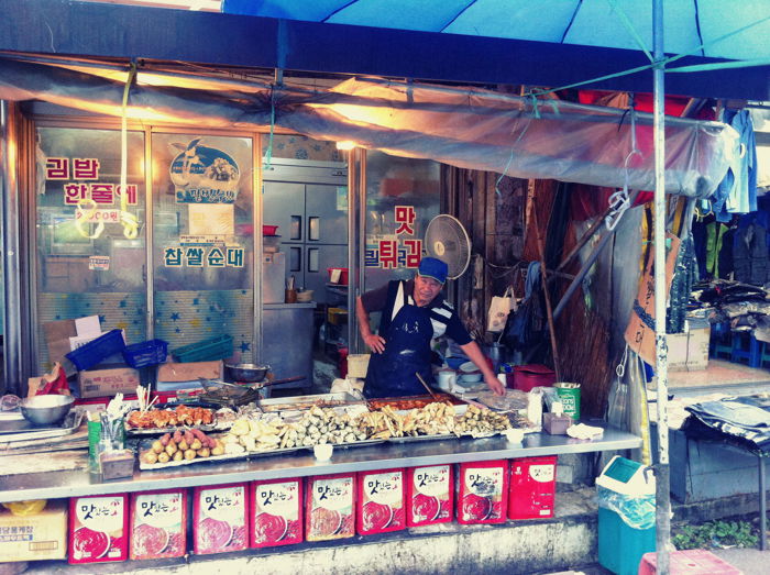 Street photo of a vendor looking after his food. 