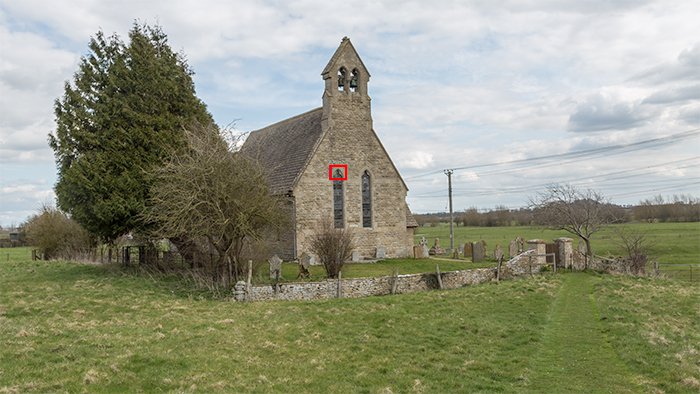 A small stone church in a countryside landscape with a visual anchor selected and highlighted in red