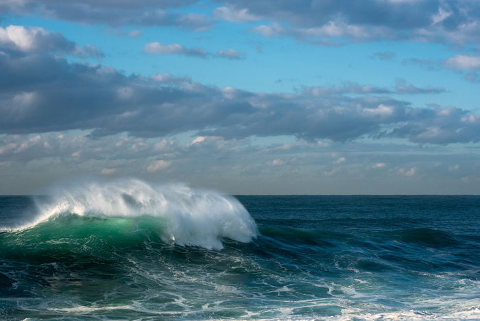 waves in turquoise blue green crystal waters, a cloudy sky overhead - water photography settings