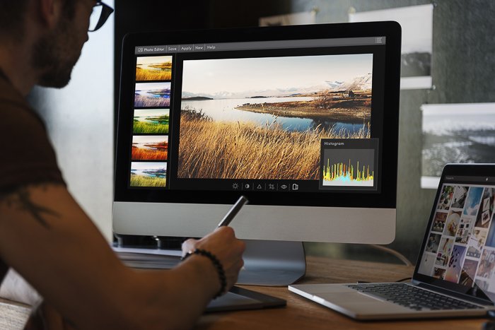 A photographer editing stock photos on a computer