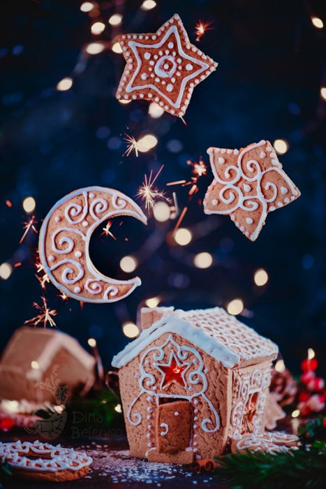 A magical Christmas still life photography shot of a gingerbread house and floating cookies