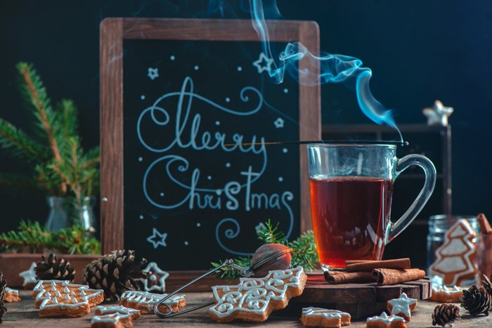 Hot tea, cookies and board with Christmas greetings 