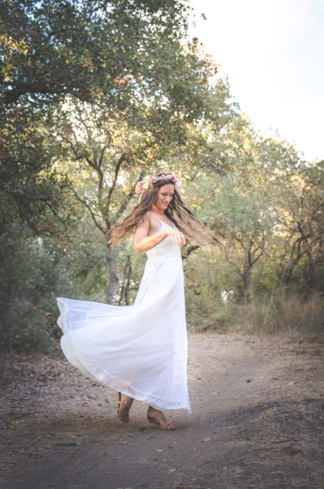 A girl in wedding dress dancing in a forest - learn photography camera settings