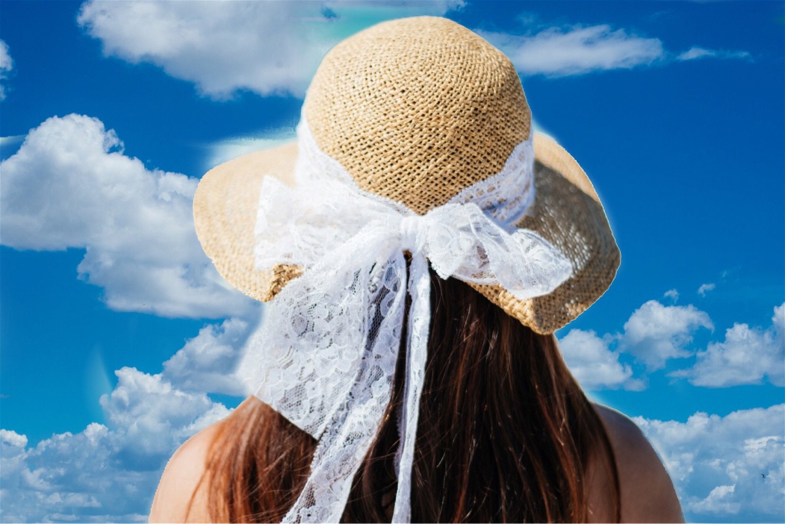 The back of a person's head and sun hat with a white lace bow against a blue sky with white fluff clouds