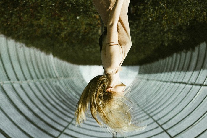 An artistic fashion photography shoot featuring a female model using an upside down perspective