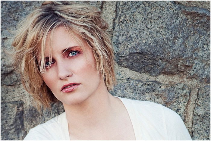 Close up beauty portrait of a blonde model posing against a stone wall