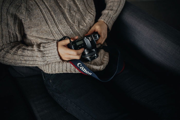 Close up of a person holding a Canon DSLR