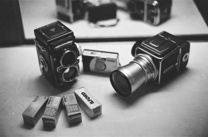 A black and white photo of two medium format film cameras