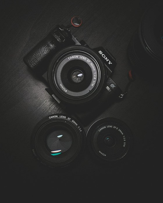 Flat lay of a sony camera beside two canon lenses