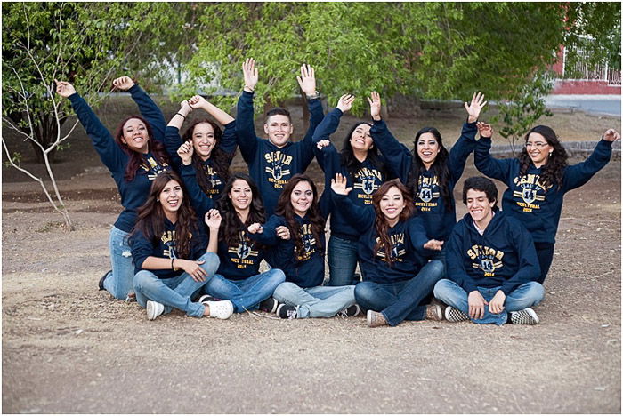 A group senior photo of a group posing in class sweaters