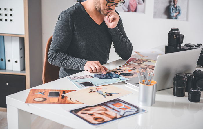 A photographer choosing prices for photography prints in a home office