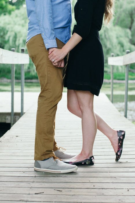 A cropped photo of a couple embracing in a natural relaxed pose in an outdoor setting