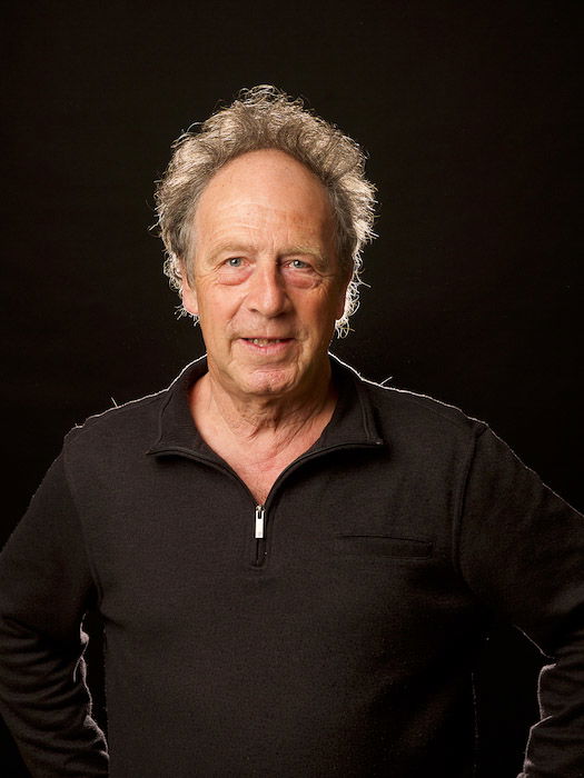 A test portrait of a man posed against a black background 