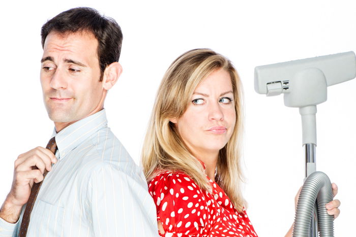 Humourous photo of a Couple dispute who should do the cleaning. with a pure white background